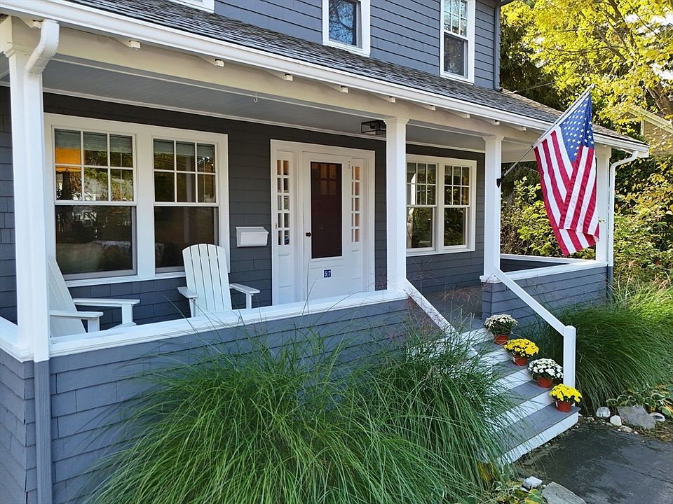 Blue house siding with white porch columns, railings and trim