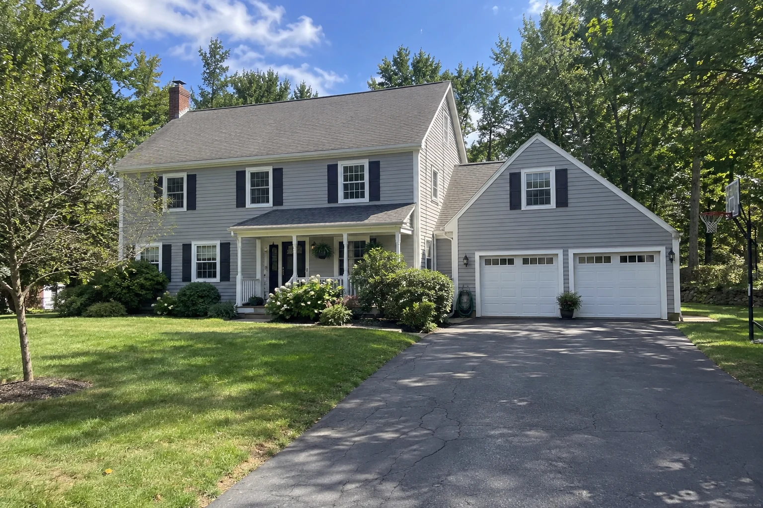Gray clapboard exterior with white trim, dark shutters and an attached garage.